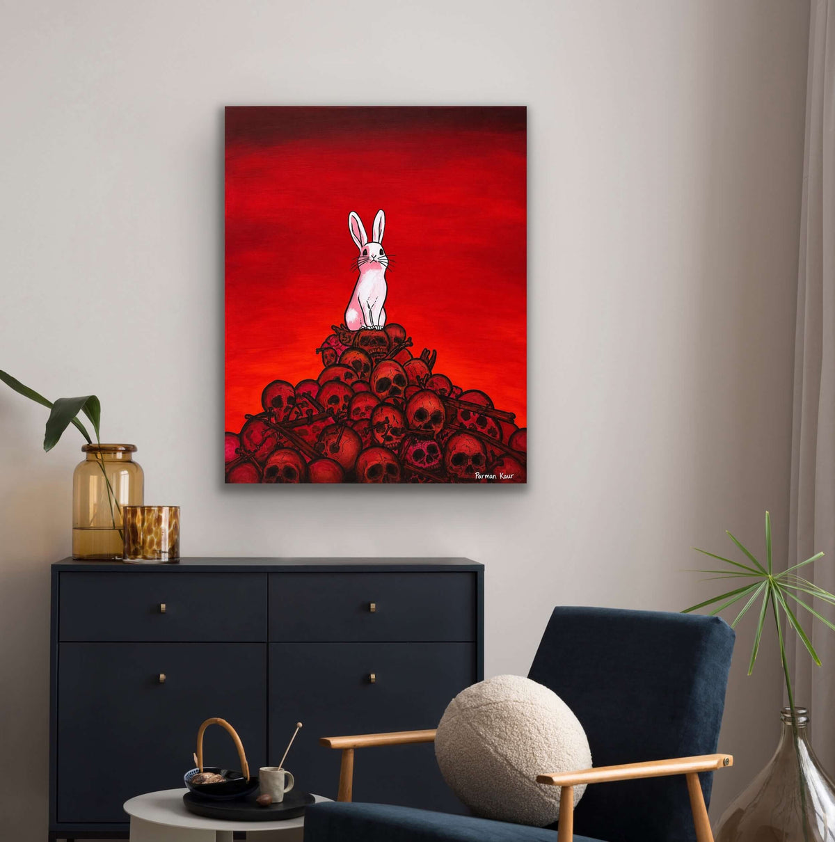 The Rabbit Among Skulls Art Print displayed in a modern living room with a striking red background.